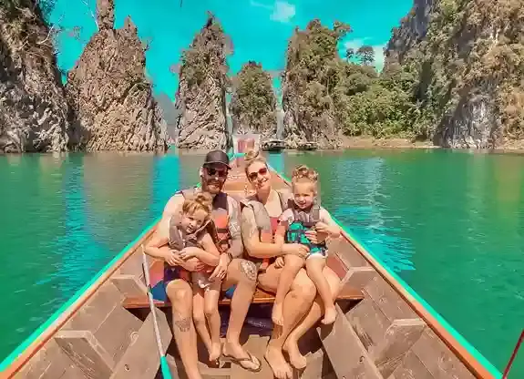 Keluarga naik perahu di Cheow Lan Lake Khao Sok, wisata Thailand dengan tebing karst