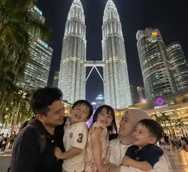 Keluarga di KLCC Kuala Lumpur malam hari untuk paket tour Malaysia dan wisata keluarga