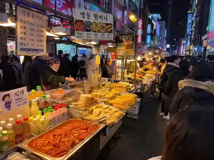 Street food Myeongdong Seoul yang ramai pembeli dengan jajanan Korea dan minuman khas Korea Selatan