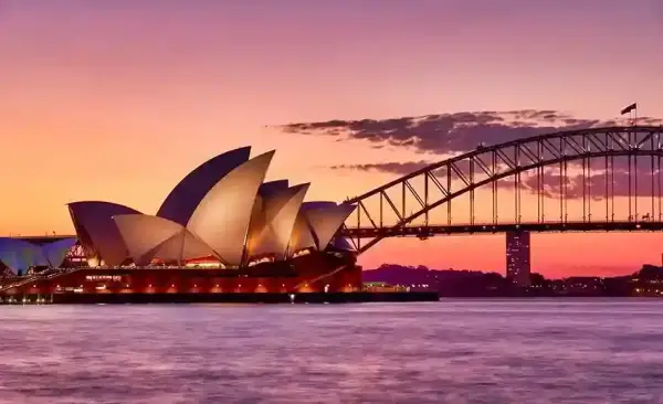 Sydney Opera House dan Harbour Bridge saat sunset di Sydney Harbour, Australia