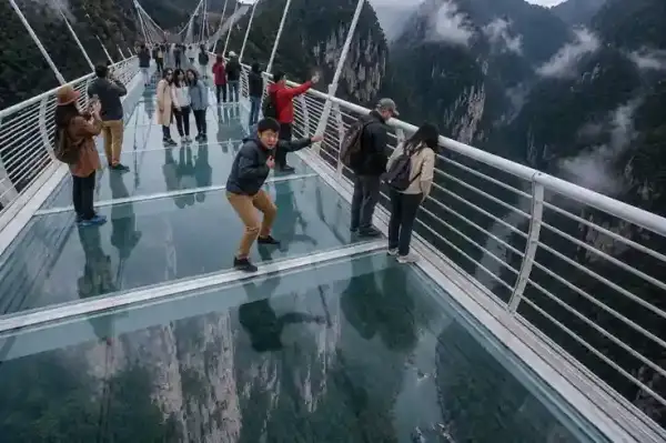 Traveler di Zhangjiajie Grand Canyon Glass Bridge dengan panorama jurang indah di China